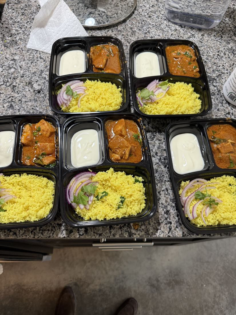 Packed ChutneyBro meal boxes of rice, curries and sides, lined up on a counter